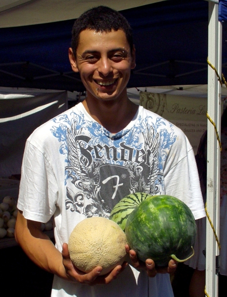 Jose from Alvarez Organic Farms holding just three varieties of their melons. Photo copyright 2009 by Zachary D. Lyons.